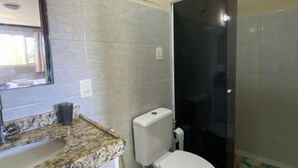 A bathroom with a toilet, sink, and shower. - Pousada Pérola do Mar (Tamandaré)