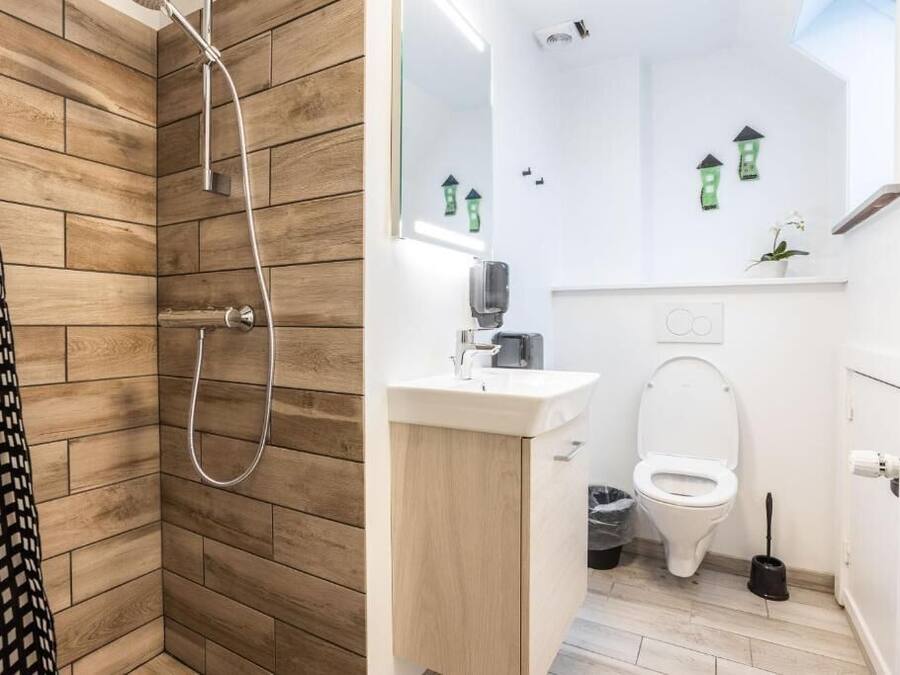 Un baño con ducha, inodoro, lavabo y espejo.