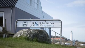 Señalización de 'B&B by the Sea Hirtshals' con vista al mar.