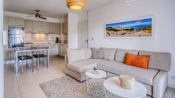 Una sala de estar moderna con un sofá, una mesa de centro y una zona de comedor con sillas y una mesa.