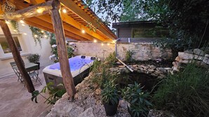 A spa area with a hot tub, wooden pergola, and string lights. - THE FRENE SUITE (Montgé-en-Goële)