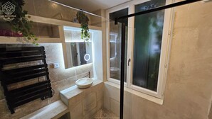 A bathroom with a stone sink, a bench, a mirror, and a glass door. - THE FRENE SUITE (Montgé-en-Goële)