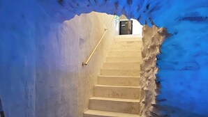 Un escalier menant à une pièce dont un des murs est bleu.