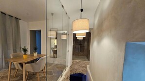 Une chambre d’hôtel moderne dotée d’un coin repas, d’un grand miroir et d’un escalier.