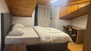 A bedroom with a bed, a desk, and a chair. - Filyos Lotus Pansiyon (Caycuma)