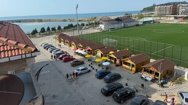 A coastal hotel with a parking lot, a sports field, and a view of the sea. - Filyos Lotus Pansiyon (Caycuma)