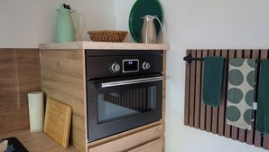 A compact kitchen with a built-in oven, a wooden countertop, a paper towel dispenser, and a towel rack. - Exceptional "Kiefer" vacation apartment (Dötlingen)