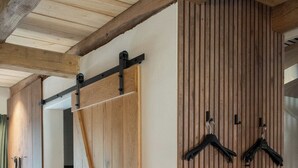 A hallway with wooden sliding doors and a coat rack. - Exceptional "Kiefer" vacation apartment (Dötlingen)