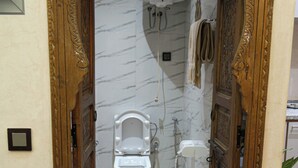 A bathroom with a toilet, shower, and a marble wall. - Dar Medina (Marrakech)