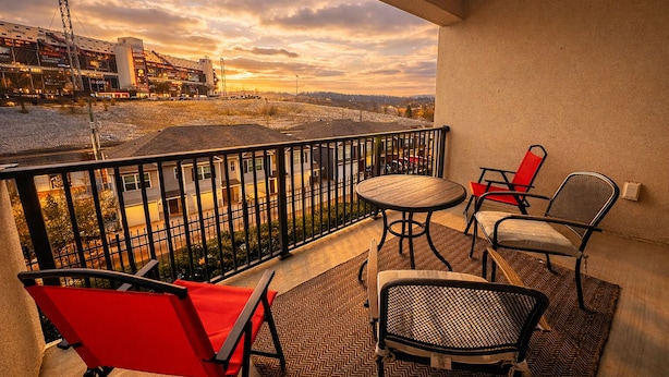 A balcony with a view of a building and a distant landscape.