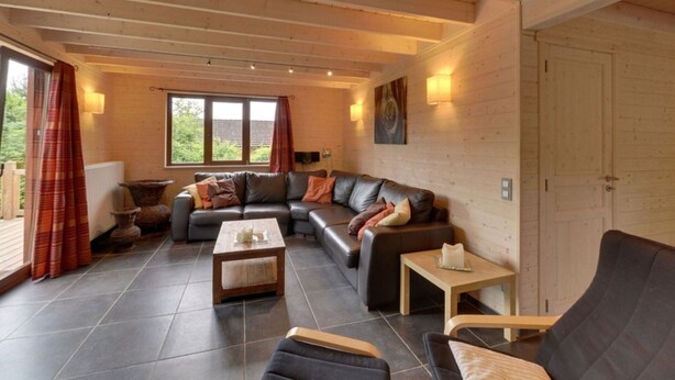 Ein gemütliches Wohnzimmer mit einer Eckcouch, einem Couchtisch und einem Kamin.