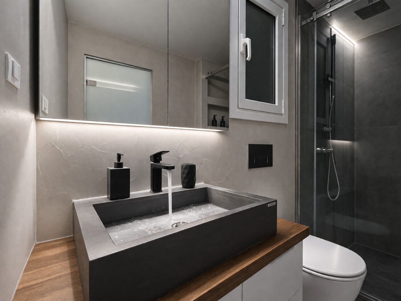 Un baño moderno con un lavabo rectangular, un espejo, un inodoro y un box de ducha.