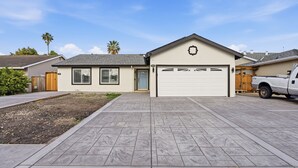 A residential house with a garage, driveway, and a wooden fence. - Modern 4BR Home, Sleeps 9, Near Silicon Valley (San Jose)