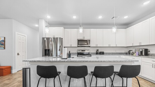 A modern kitchen with white cabinets, stainless steel appliances, and a granite countertop. - Down-Town/ Alamo dome/tower of americas/ hemisphere park (San Antonio)
