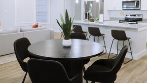 A modern kitchen with a central island, a dining area with a round table and chairs, and a ceiling light fixture. - Down-Town/ Alamo dome/tower of americas/ hemisphere park (San Antonio)