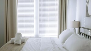 A hotel room with a bed, a lamp, and a window with blinds. - Down-Town/ Alamo dome/tower of americas/ hemisphere park (San Antonio)