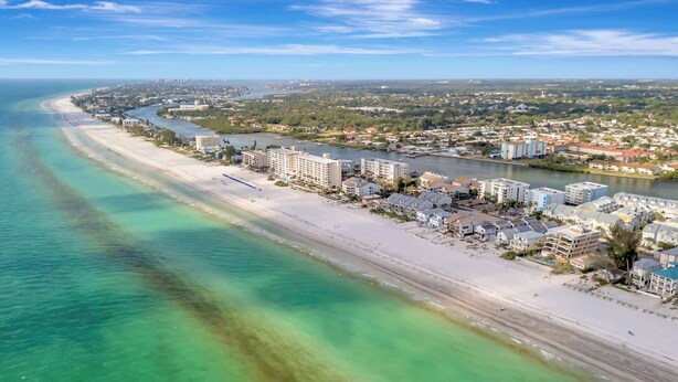 A coastal cityscape with a beach, river, and residential buildings. - 4BR Beachfront Balcony Condo | Partial Ocean View (Indian Shores)