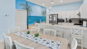 A kitchen with white cabinets, a stainless steel refrigerator, and a microwave. - 4BR Beachfront Balcony Condo | Partial Ocean View (Indian Shores)