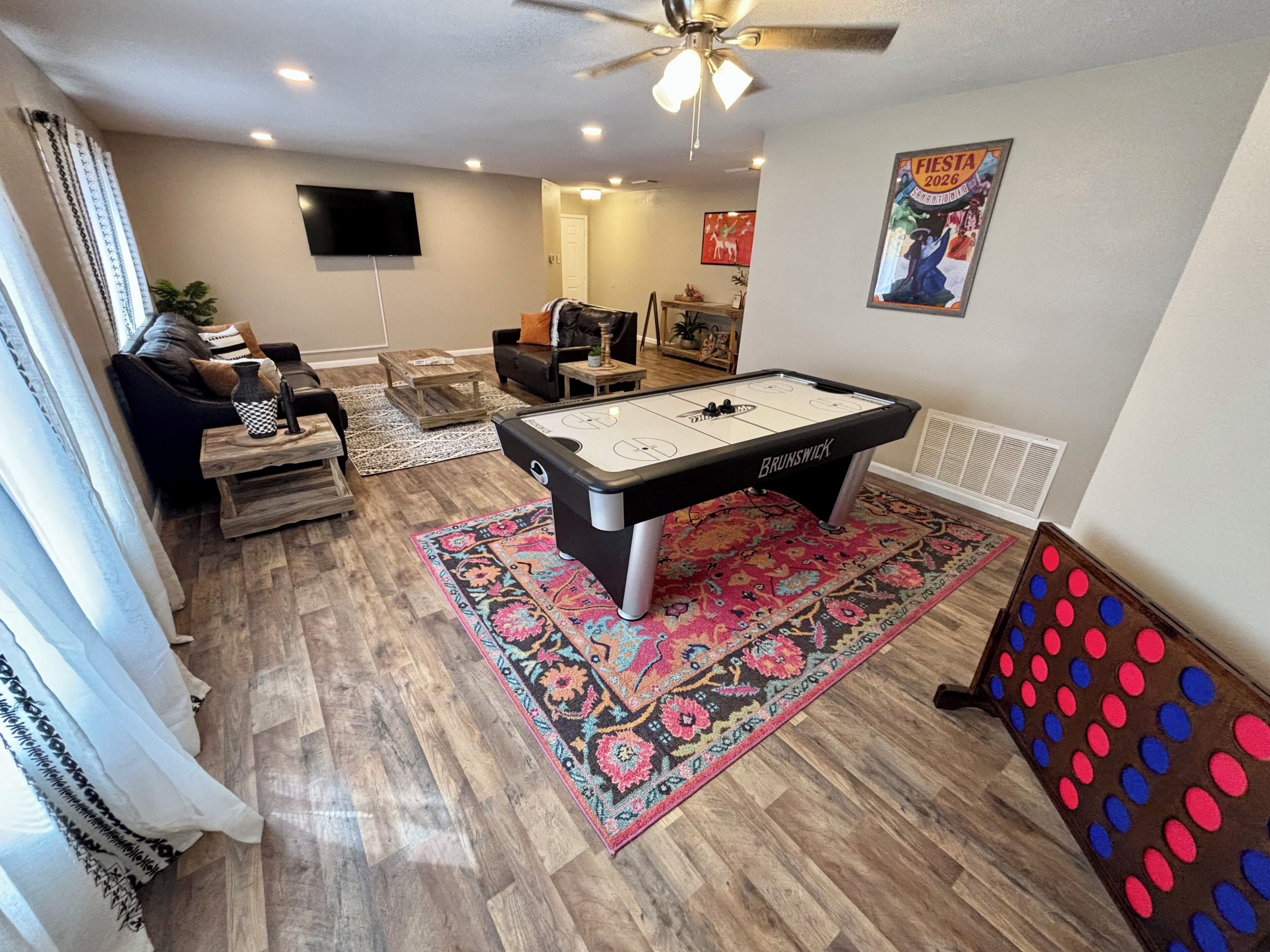 A pool table, a sofa, a TV, and a poster on the wall.