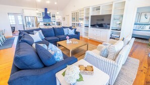 Een moderne woonkamer met een blauwe bank, een salontafel en een televisie.