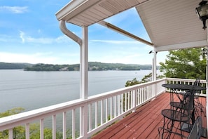 A covered outdoor area with a view of a lake and distant hills. - Lakeview Manor With Historic Charm and Serene Waters (Osage Beach)