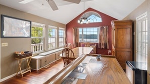 A spacious kitchen with a large island, wooden cabinets, and a ceiling fan. - Lakeview Manor With Historic Charm and Serene Waters (Osage Beach)