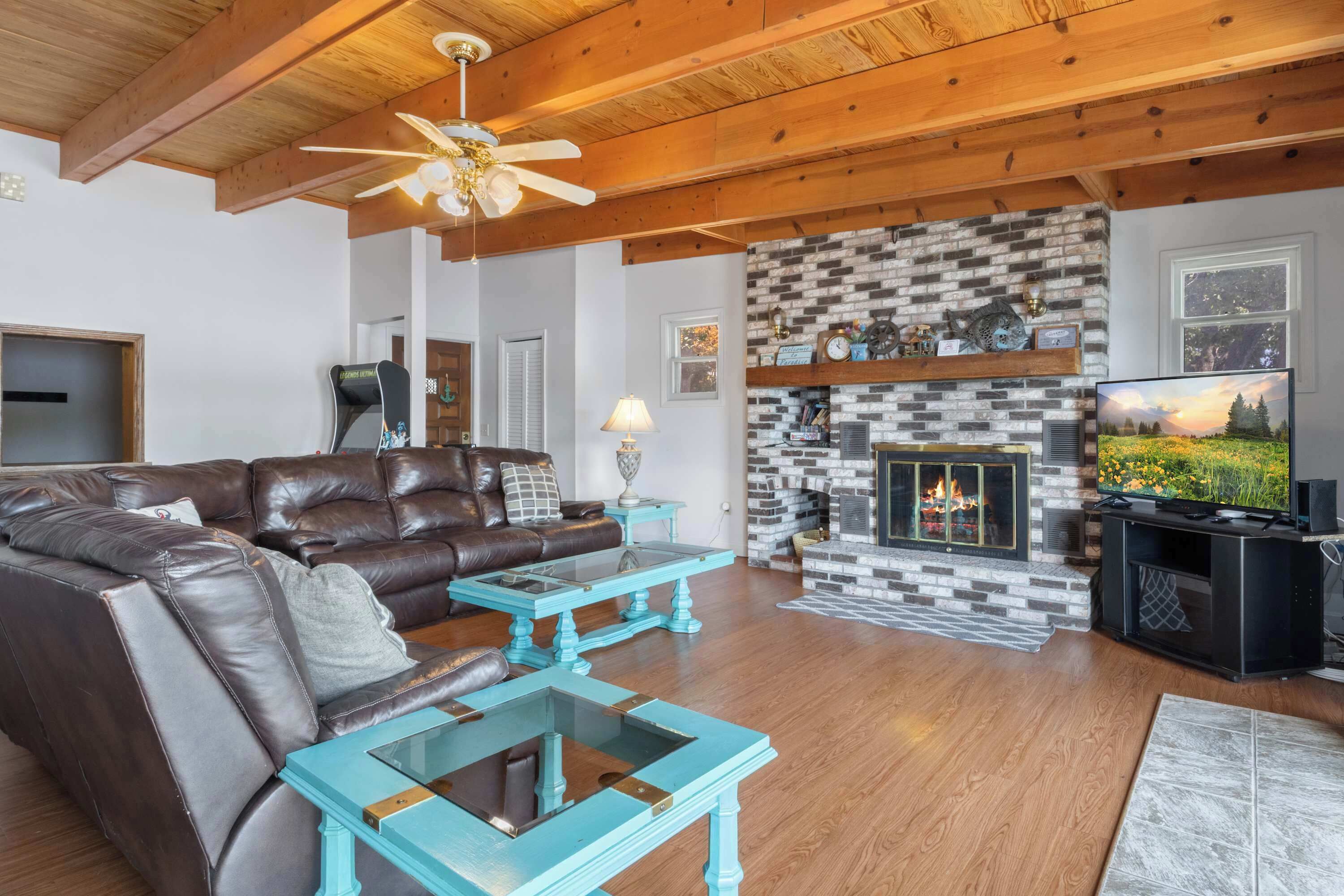A living room with a fireplace, leather sofa, and a television.