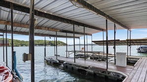 Zona de muelle cubierta con bancos de madera y rampa para embarcar y desembarcar barcos.