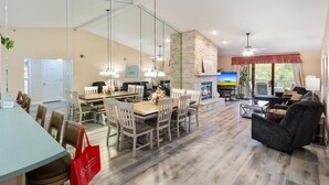 A spacious living area with a fireplace, dining table, and seating. - Lakefront Condo Near the State Park (Osage Beach)