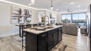 A modern kitchen with a central island, large windows, and a view of the city. - Waterview Retreat in Osage Beach With Public Dock and Community Pool (Osage Beach)