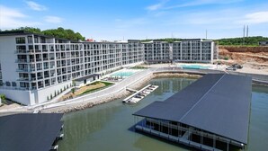 A modern hotel with a large pool, a covered outdoor area, and a waterfront view. - Waterview Retreat in Osage Beach With Public Dock and Community Pool (Osage Beach)