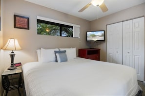 A hotel room with a bed, a TV, a clock, a window, and a wardrobe. - Lakefront Condo Near Margaritaville (Osage Beach)