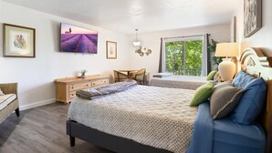 A bedroom with two beds, a desk, a chair, a dresser, and a large window with a view of trees. - Margaritaville Family House Next to Pool (Osage Beach)