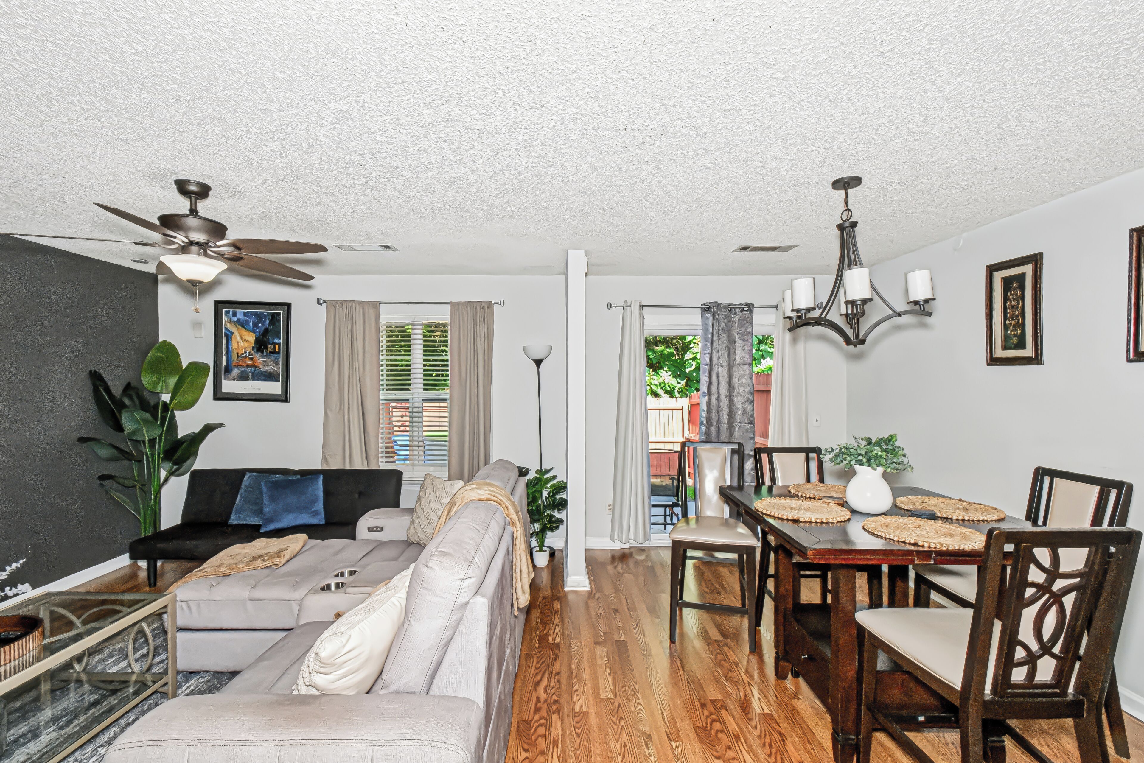 A living room with a sofa, dining table, and chairs.
