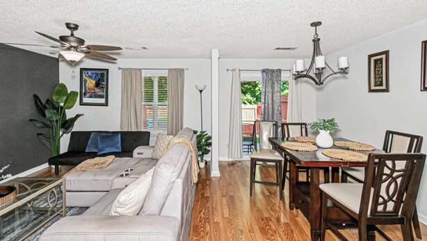 A living room with a sofa, dining table, and chairs.
