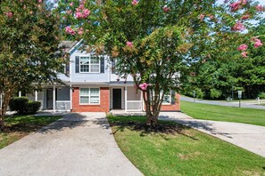 A two-story house with a front porch, a driveway, and a well-maintained lawn. - Quiet Family 4BR l 3 Full Baths l Near ATL Airport l Sleeps 9 (Union City)