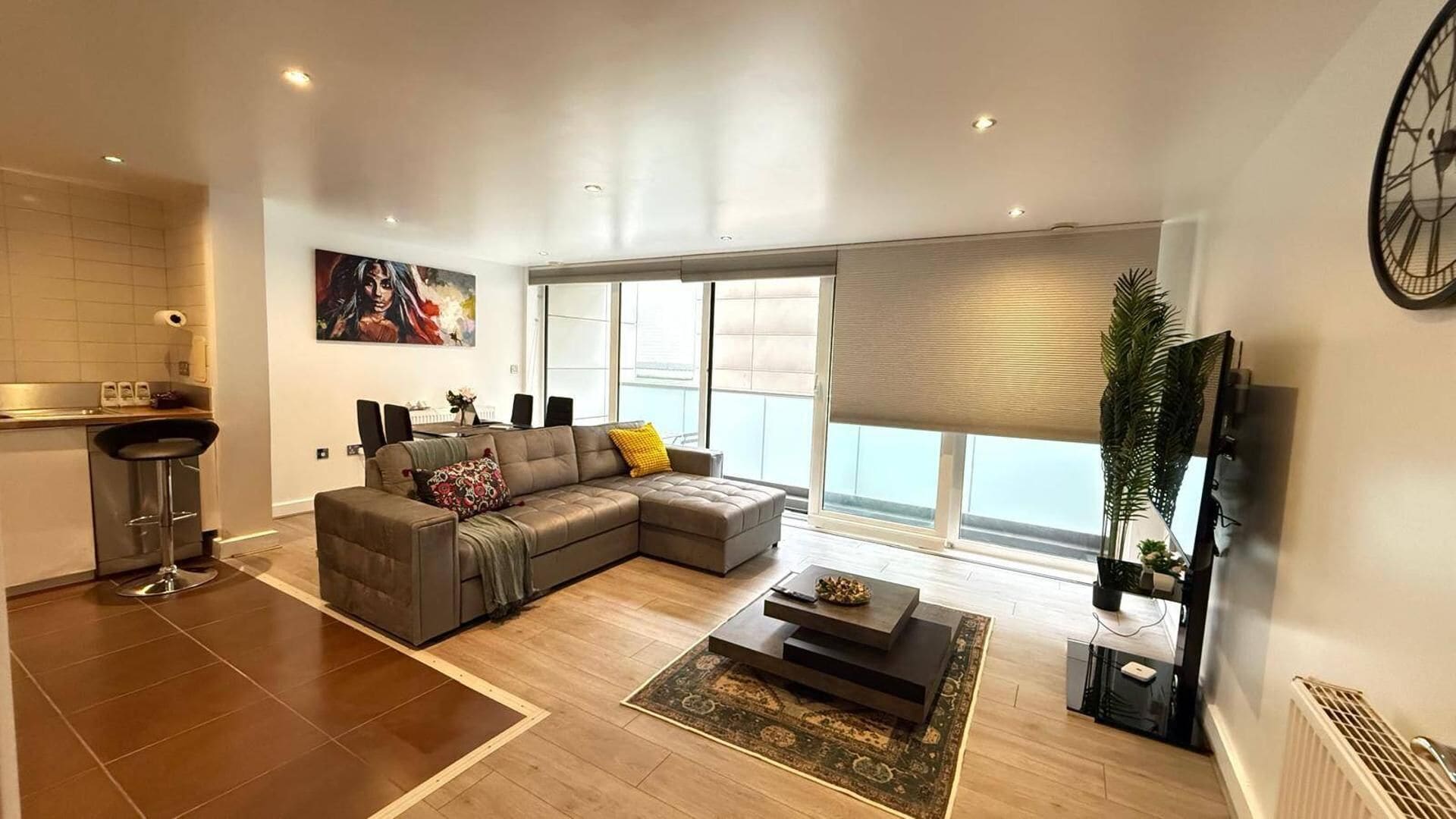 Una sala de estar moderna con un sofá modular, comedor y cocina.