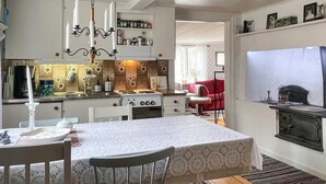 A compact kitchen with a dining area, a built-in stove, and a small dining table with chairs. - 2 Person Holiday Home in Morlunda (Mörlunda)