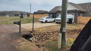 A residential area with houses, a driveway, a mailbox, and a utility pole.