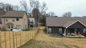 A residential area with houses, a wooden fence, and a lawn.