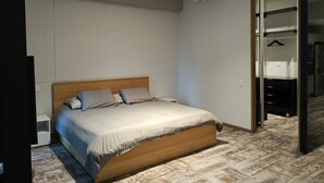 A bedroom with a wooden bed, a white wall, an air conditioning unit, and a closet with a mirror. - Modern apartment with pool and gym in TOP location in the CDMX (Ciudad de México)
