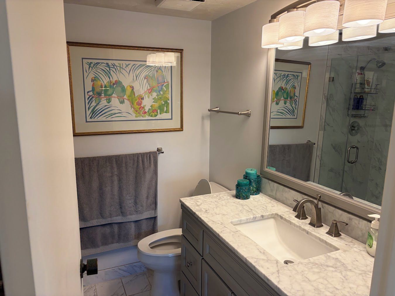 Une salle de bain comprenant des toilettes, un lavabo, un meuble-lavabo et un espace douche.