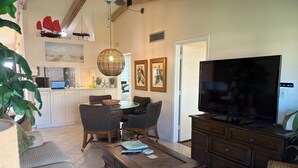 A living room with a television, sofa, coffee table, and dining area. - Great beach access, central location, 2-bedroom condo in wonderful Marco Island (Marco Island)