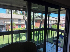 A room with a view of a balcony, a chair, and a building in the background. - Great beach access, central location, 2-bedroom condo in wonderful Marco Island (Marco Island)