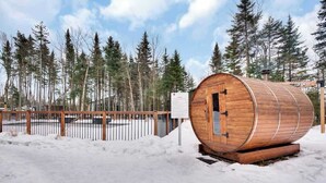 A wooden sauna structure in a snowy forest setting. - Atlas | Familial | Piscine & Spa by Alchalet (Pont-Rouge)