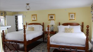 Ein Doppelbett mit Holzrahmen, ein Nachttisch mit Lampe und ein Teppich mit Blumenmuster.