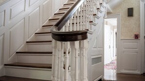 Eine Treppe mit weißen Balustraden und Holzstufen, die zu einer oberen Etage führt.