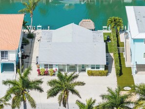 A building with a flat roof, a balcony, and a view of a calm body of water.