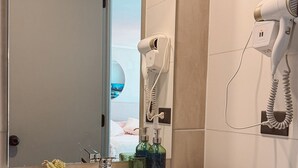 A bathroom with a sink, mirror, hairdryer, and toiletries. - Escapada en Valparaíso (Valparaíso)