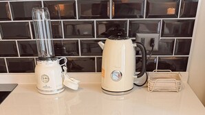 A kitchen with a blender, kettle, and a drawer with kitchen utensils. - Escapada en Valparaíso (Valparaíso)